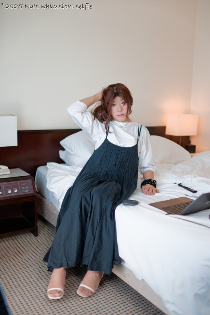 ホテルのベッドで髪を整えるアラカン女性の自然なセルフポートレート by SONY α1+LA-EA5 + MINOLTA 35mm F1.4G